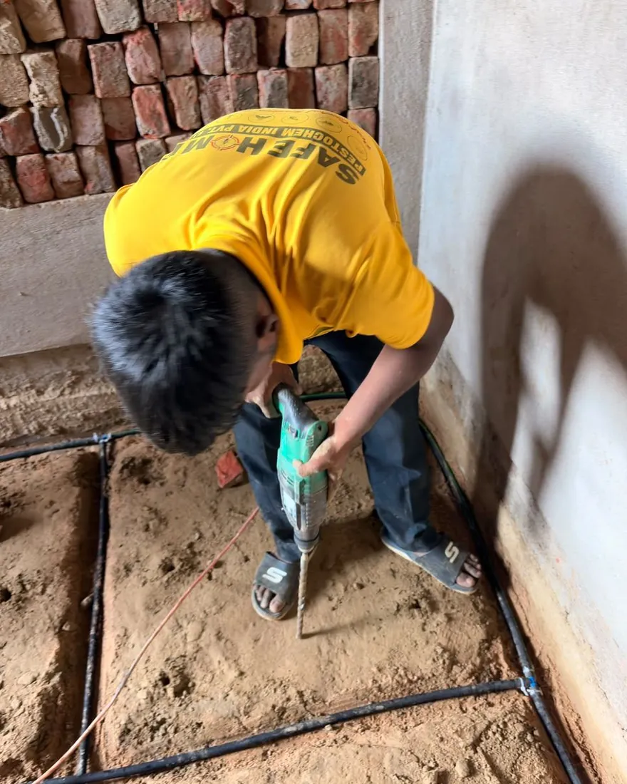 Safe Home Pestochem technician: laying a porous-pipe termite reticulation system in a foundation trench