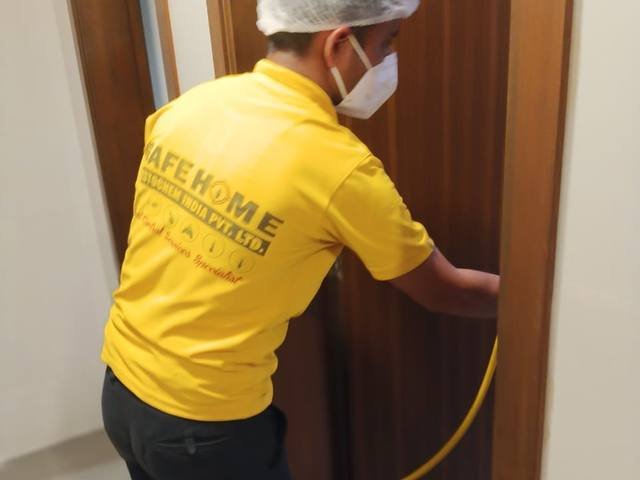 Treating guest room door frames along a hotel corridor